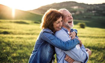 Image Text: 500x332_0011_Side view of senior couple hugging outside in spring nature at sunset.
