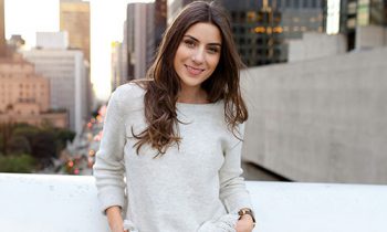 Image Text: 500x332_0042_Beautiful young woman sitting on a bridge across the boulevard in urban scenery, downtown, at sunset, smili
